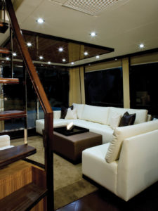 Majilite-covered ceiling panels, faux-leather couch upholstery and a mock-croc cushion (Valtekz Crocodile in Truffle) create an atmosphere that invites relaxation aboard the Lazzara Breeze 76 motor cruiser. Sharp contrasts in color and texture add visual interest to any interior. Photo: Lazzara Yachts.