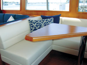 The dinette upholstery on this East Bay 55 is covered with an easily cleanable fabric having a 100-percent polyurethane surface. Vinyl fabrics are often used in dinettes, while woven fabrics may be used in salons and staterooms. Photo: Onboard Interiors LLC.