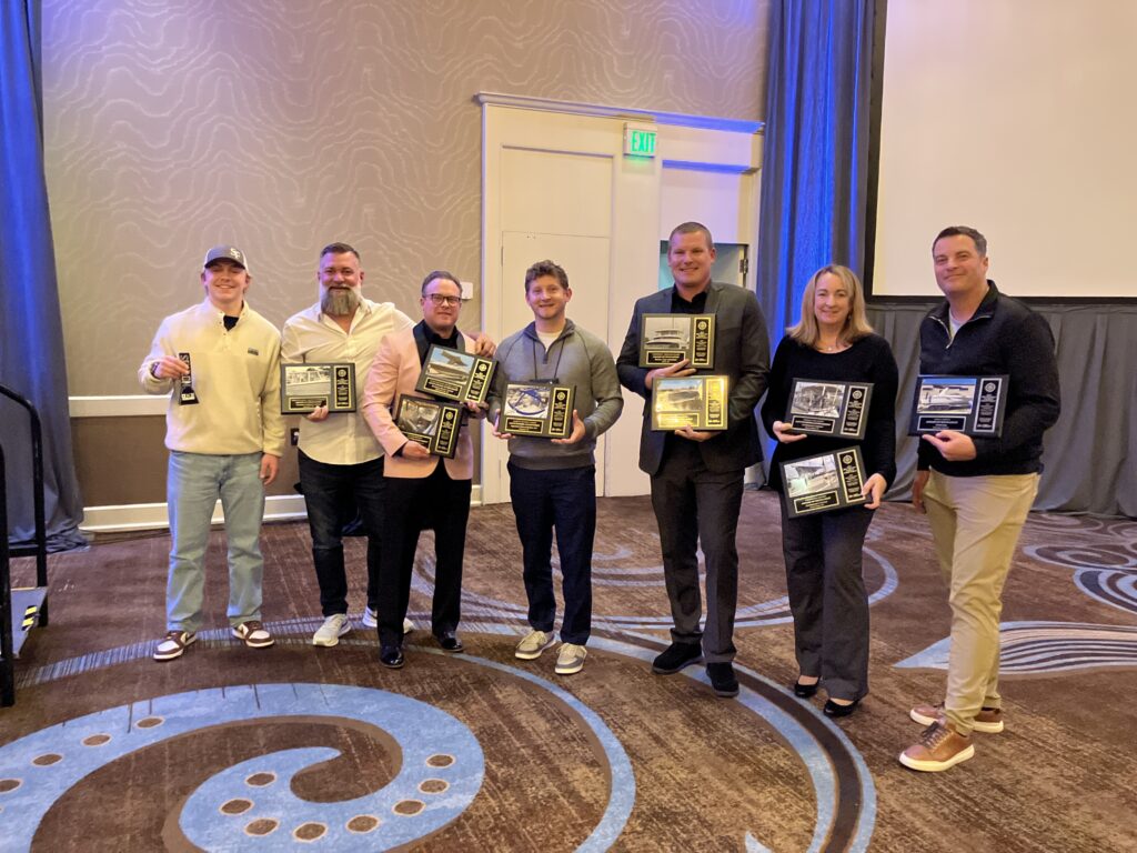 Seven MFA Excellence Awards winners holding their plaques.