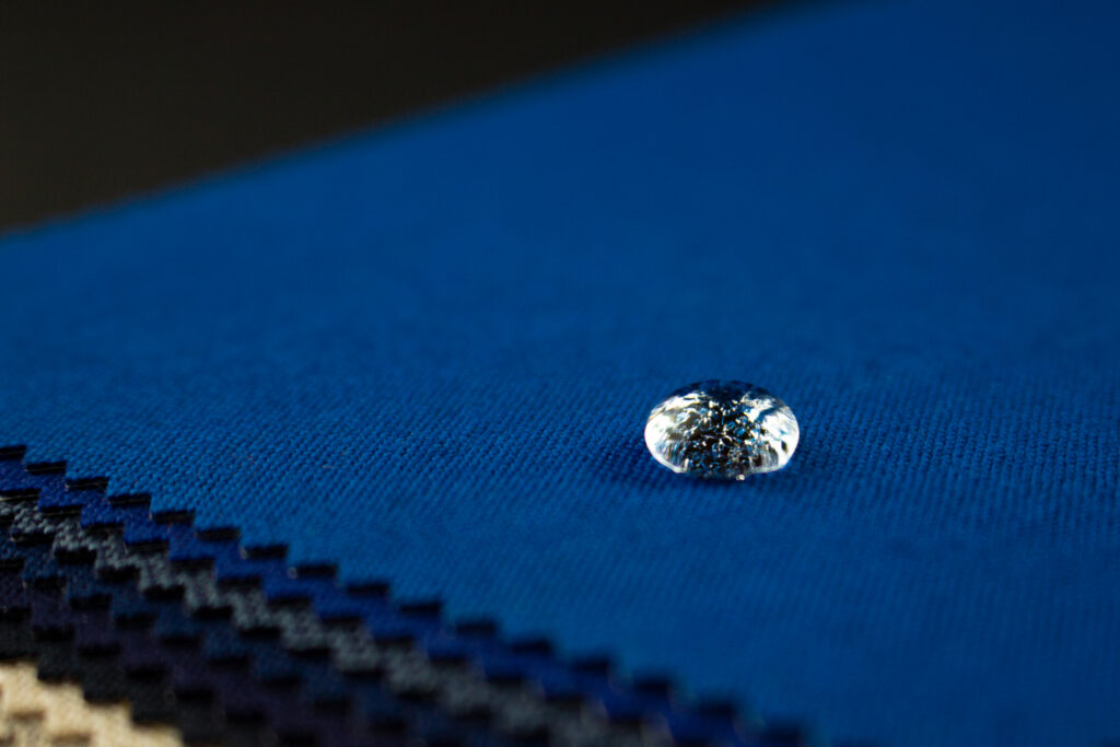 A droplet of water on a stack of Sunbrella fabric.
