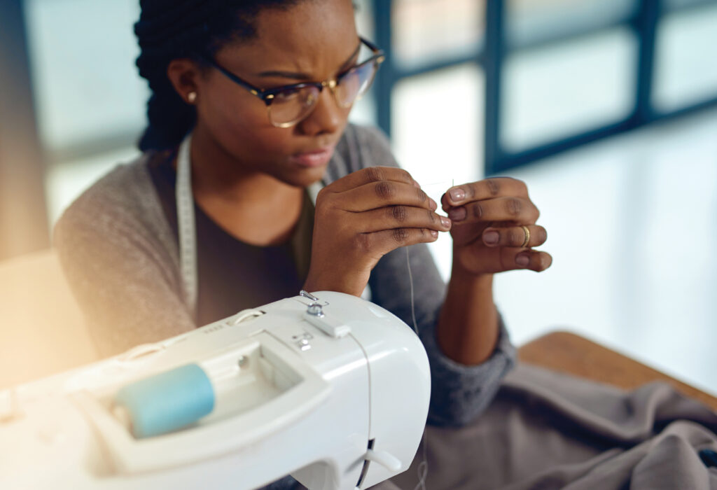 A fabricator using a sewing machine.