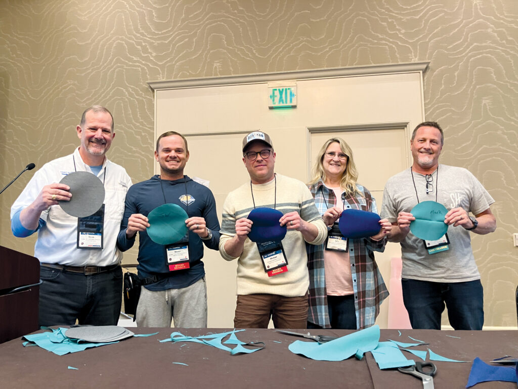 (from left to right) Derek Robinson, Steven Wayne, Mike Boatman, Julie Jacobs and Mark Peterson holding fabric projects from the 2025 Fabricator Olympics.