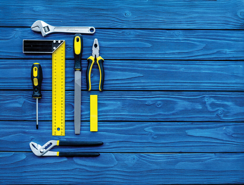 Seven handheld tools arranged in a neat rectangle on a blue background.