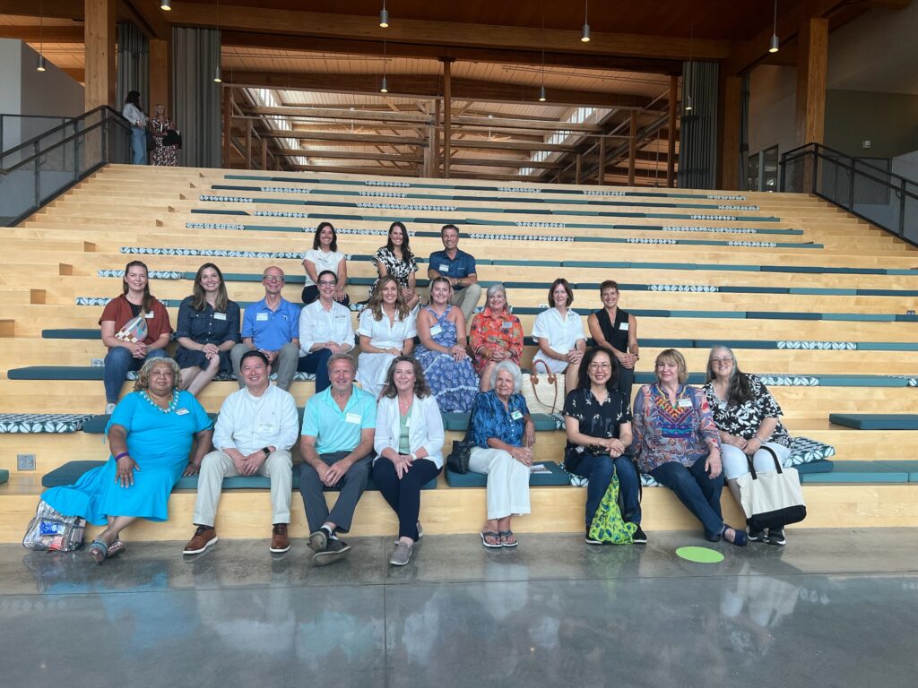 Over a dozen people sit on a flight of stairs.