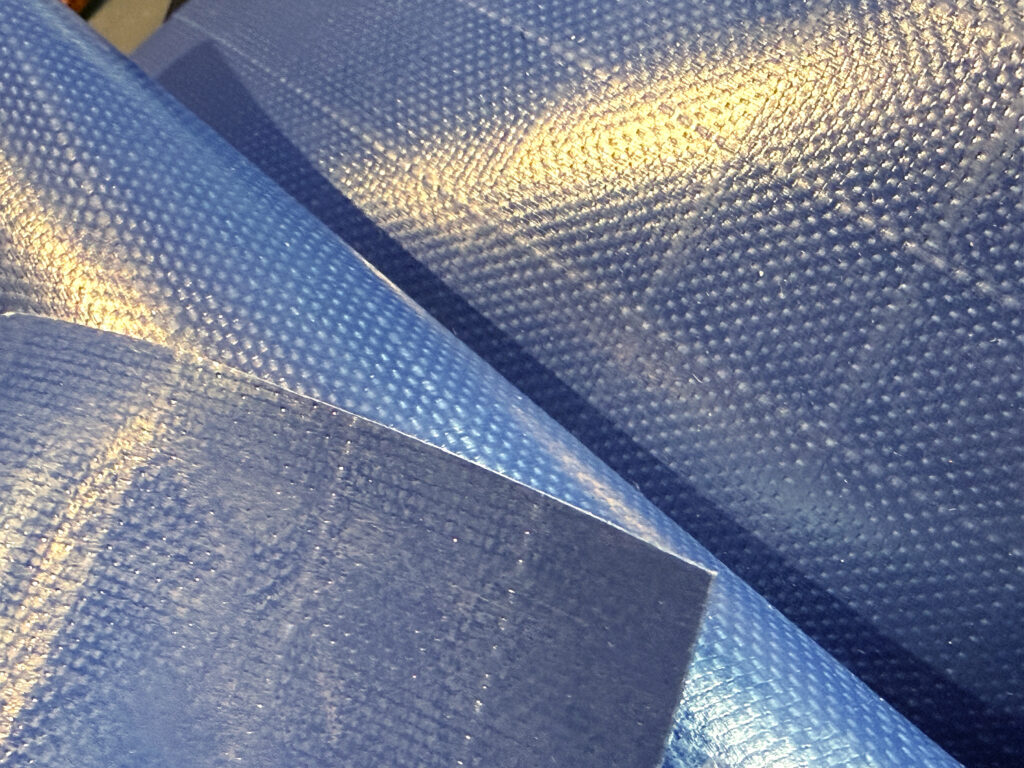 Textured navy blue PVC fabric arranged in overlapping layers.