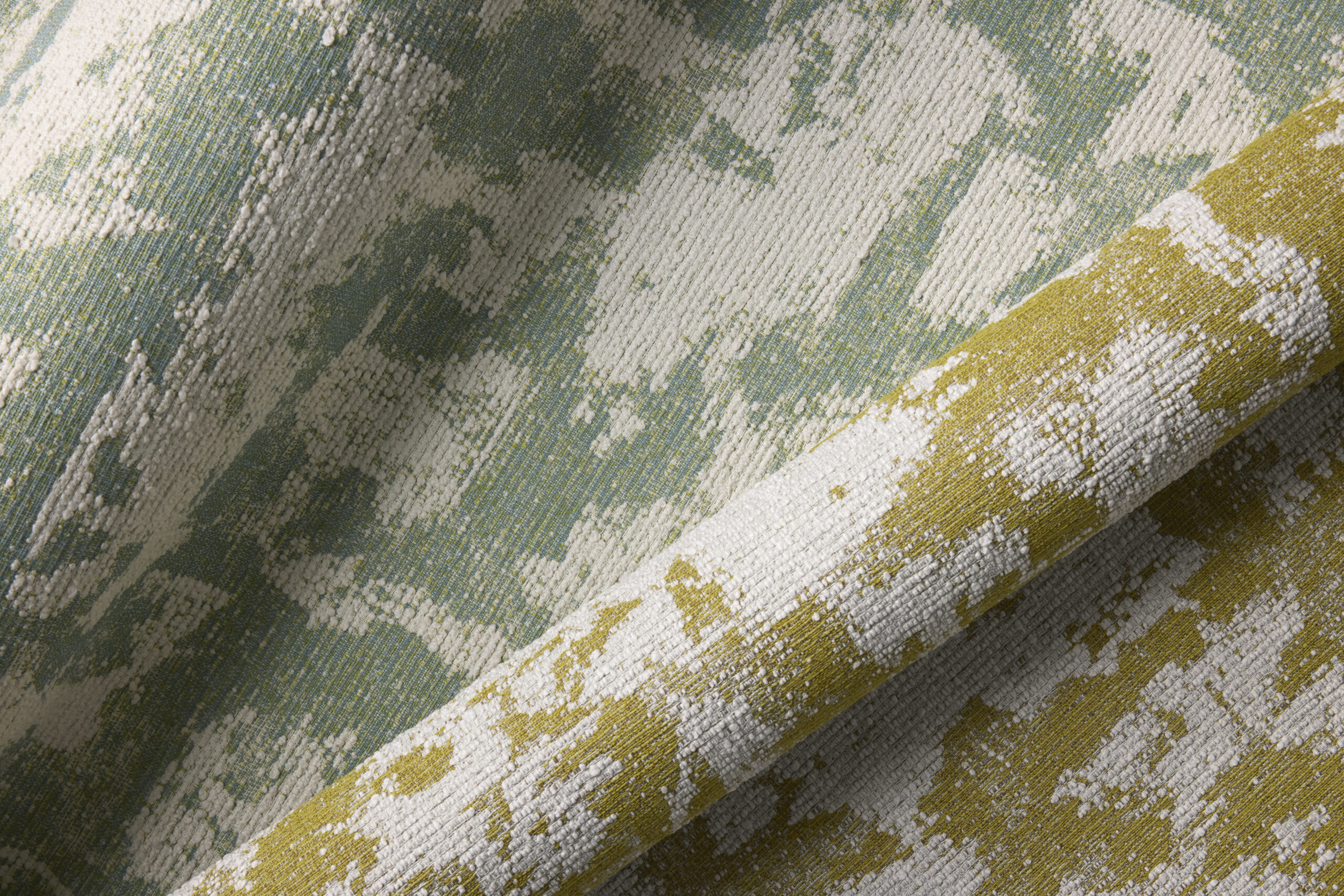 Textured fabric featuring a blend of soft green, white and yellow hues, showcasing a subtle, abstract pattern.