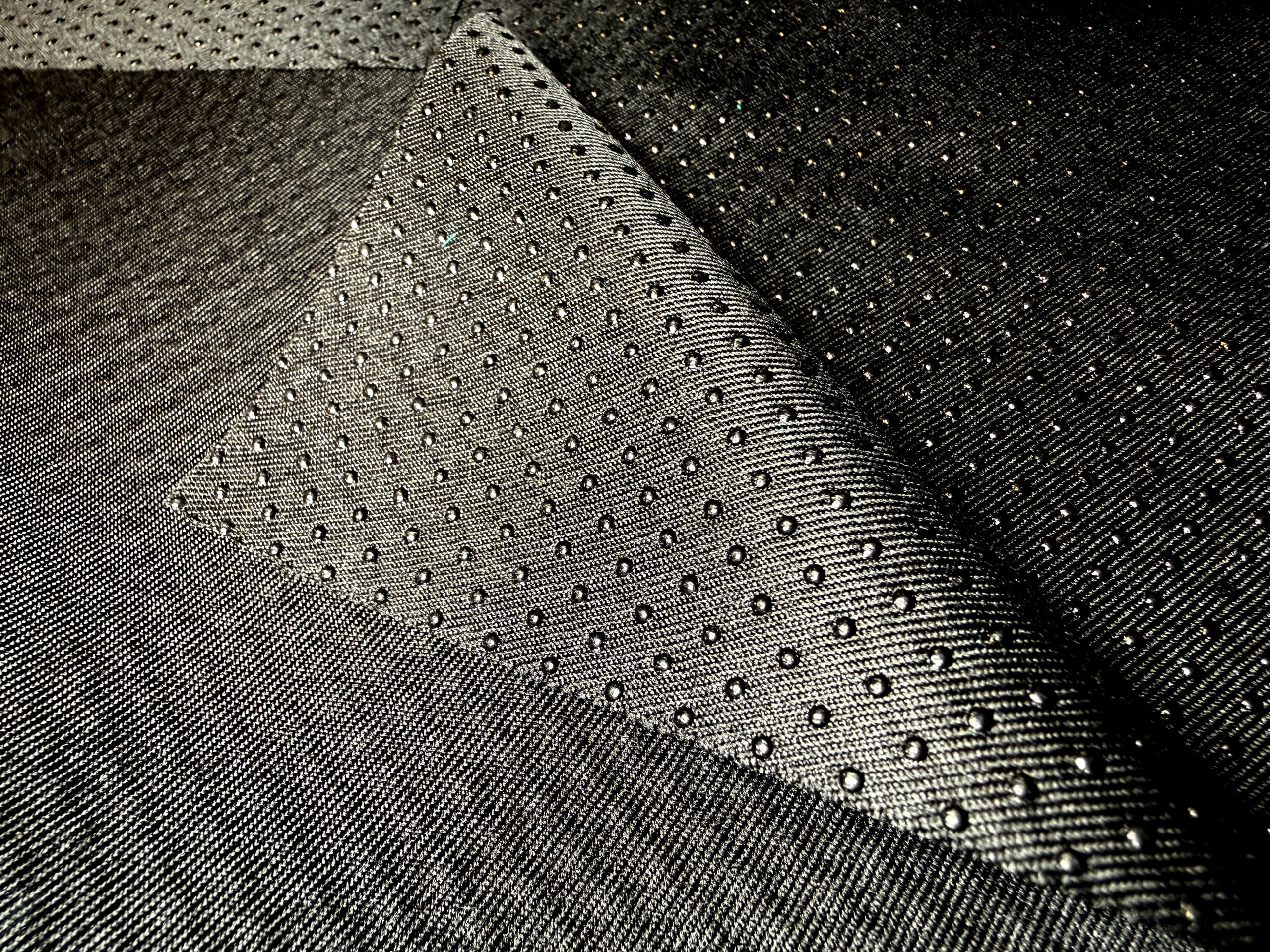 Textured black marine fabric showcasing a woven pattern with raised dots.